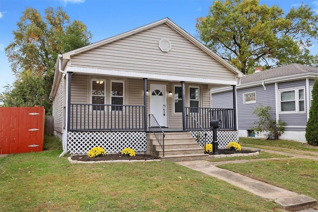 bungalow-style house with a front yard and covered porch