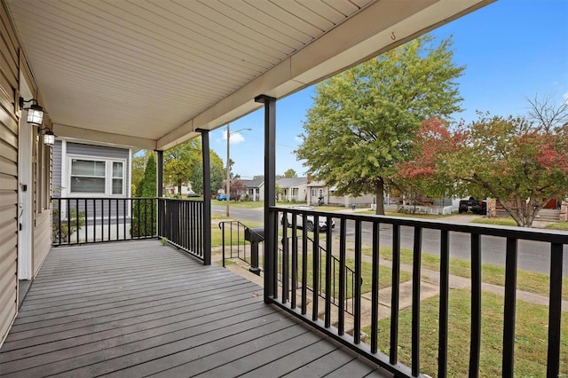 wooden deck with a yard and covered porch