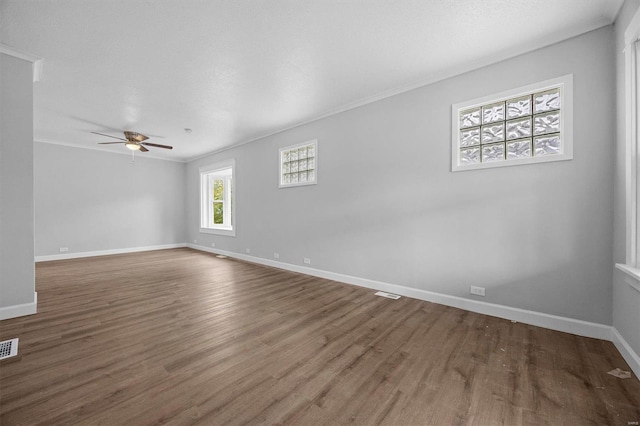 empty room with ornamental molding, ceiling fan, and dark hardwood / wood-style flooring