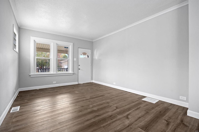 spare room featuring a textured ceiling, ornamental molding, and dark hardwood / wood-style floors