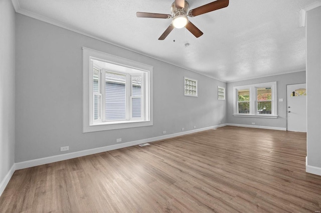 empty room featuring ornamental molding, hardwood / wood-style floors, a textured ceiling, and ceiling fan