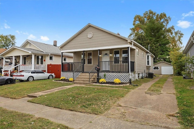 bungalow-style house featuring a front yard, an outdoor structure, a garage, and a porch