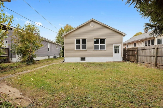 back of house featuring central AC and a lawn