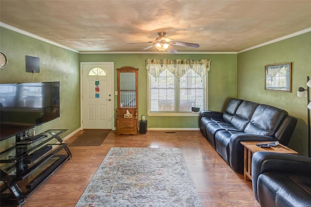 living room with hardwood / wood-style flooring, ceiling fan, and ornamental molding