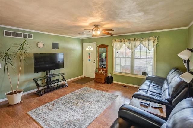 living room featuring crown molding, hardwood / wood-style flooring, a textured ceiling, and ceiling fan