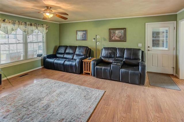 living room with ceiling fan, crown molding, and light wood-type flooring