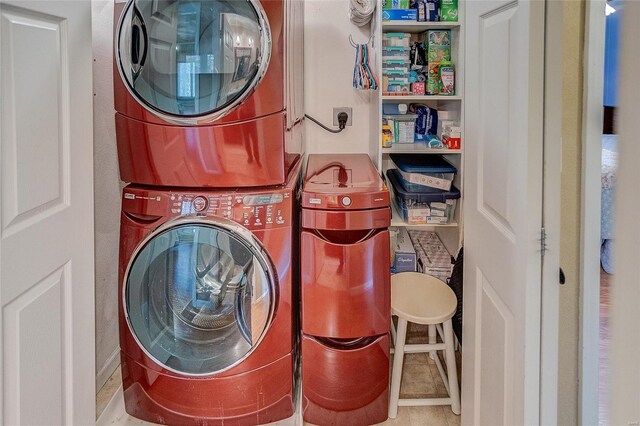 laundry area featuring tile patterned floors and stacked washing maching and dryer