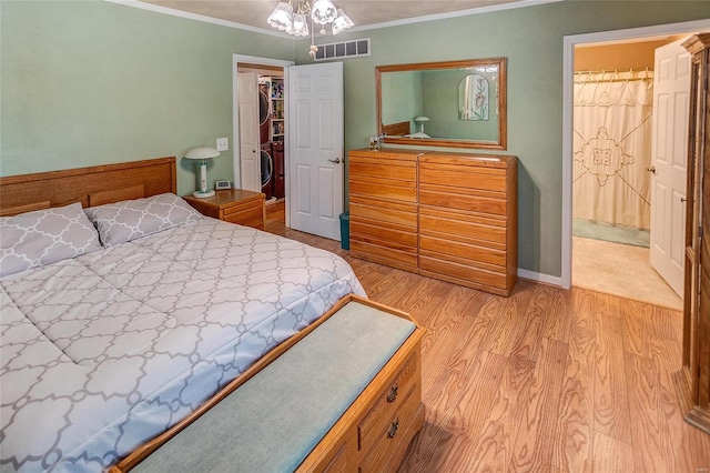 bedroom with light wood-type flooring, ensuite bathroom, and ornamental molding