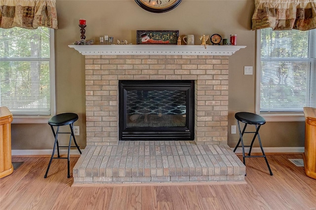 interior details with a brick fireplace and hardwood / wood-style flooring