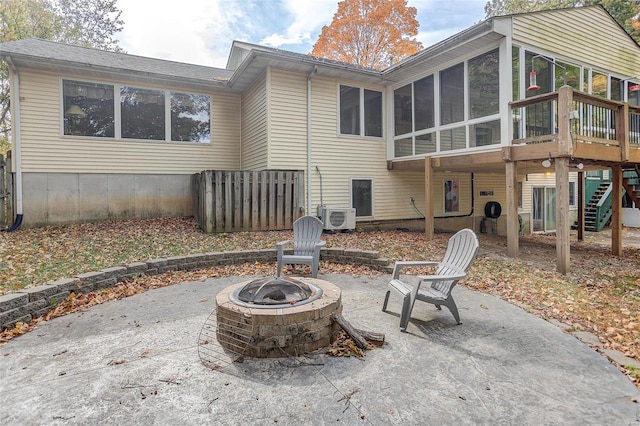 back of property with ac unit, a sunroom, a fire pit, and a patio