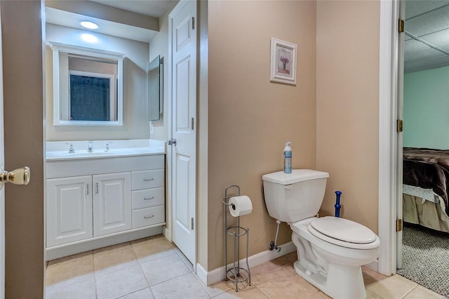 bathroom with toilet, vanity, and tile patterned flooring