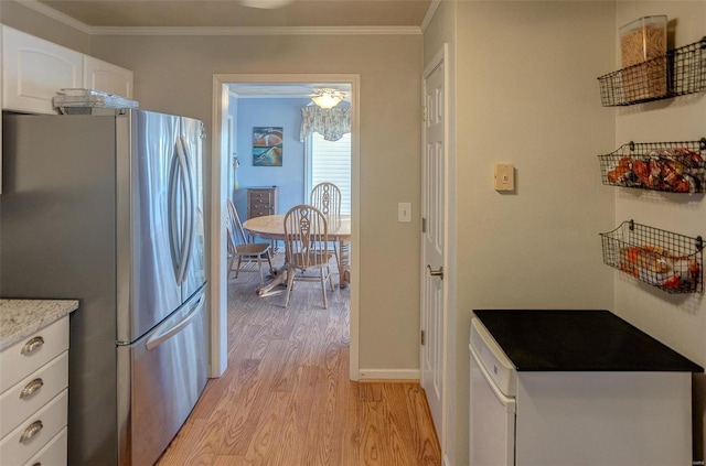 kitchen with white cabinets, light hardwood / wood-style flooring, crown molding, and stainless steel fridge