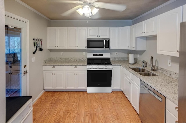 kitchen with crown molding, light hardwood / wood-style flooring, appliances with stainless steel finishes, sink, and white cabinets