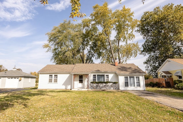 view of front of property featuring a front yard, an outbuilding, and a garage