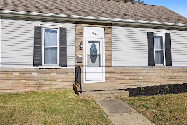 view of exterior entry with a yard