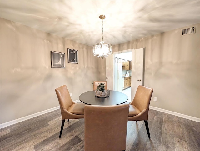 dining space featuring an inviting chandelier and dark hardwood / wood-style flooring