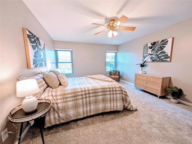 carpeted bedroom with multiple windows and ceiling fan