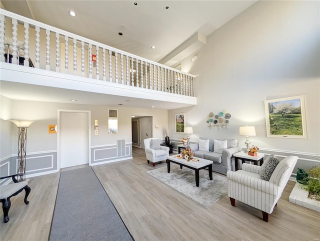 living room featuring a high ceiling and light hardwood / wood-style flooring