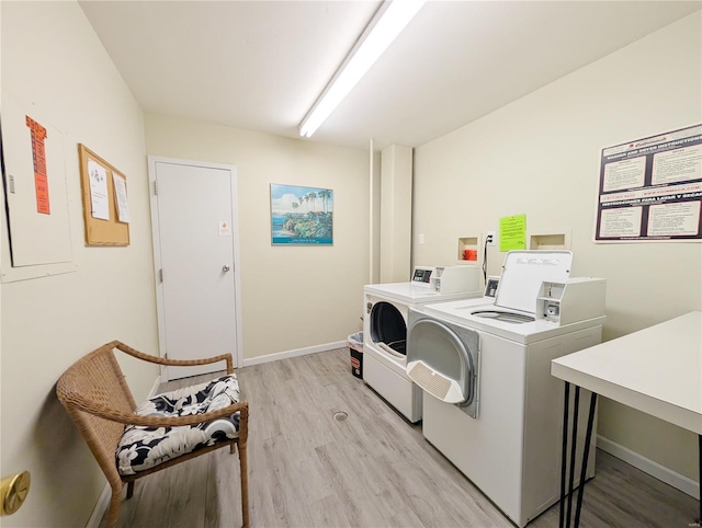 laundry room with washer and dryer and light hardwood / wood-style floors