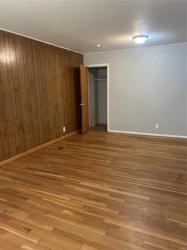 unfurnished room featuring wood walls and light hardwood / wood-style floors