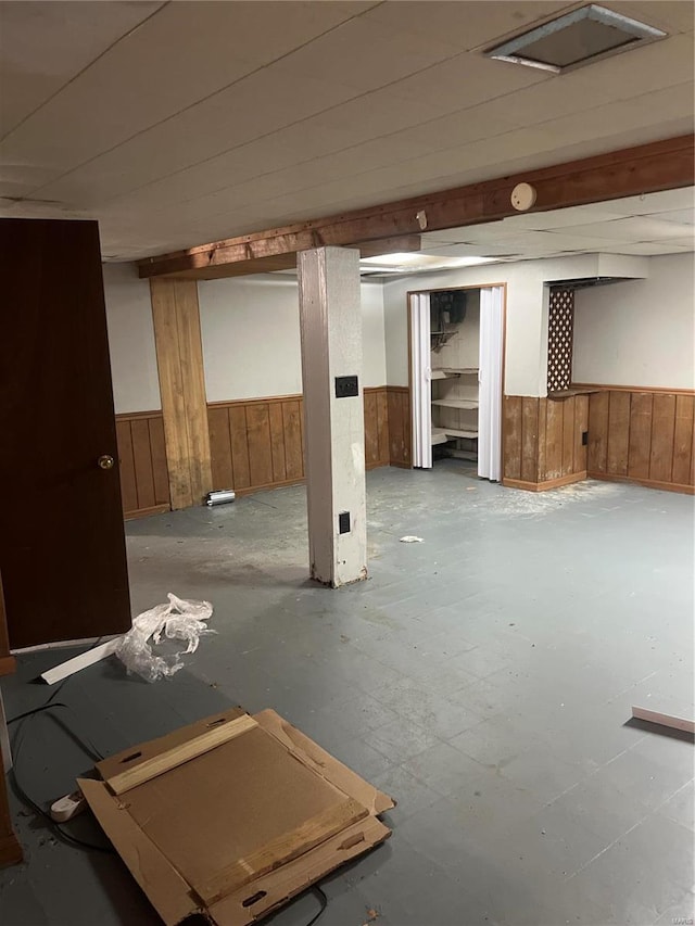 basement featuring wood walls