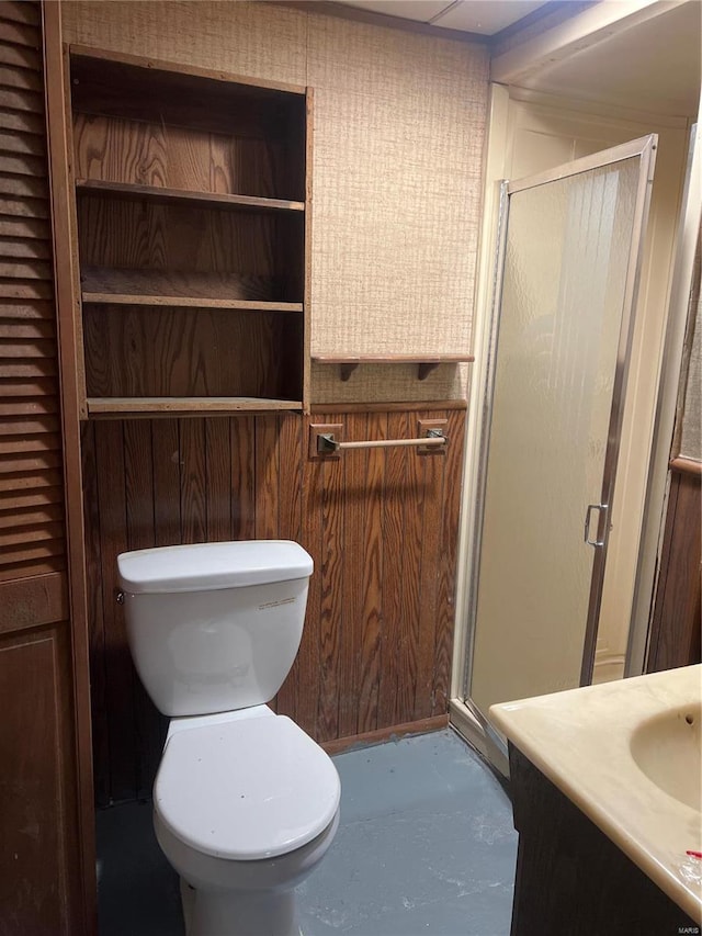 bathroom with walk in shower, vanity, toilet, and wooden walls