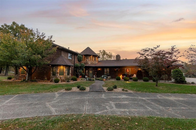 view of front of property featuring a chimney and a yard