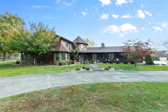 view of front of home with a front lawn, stone siding, and a chimney