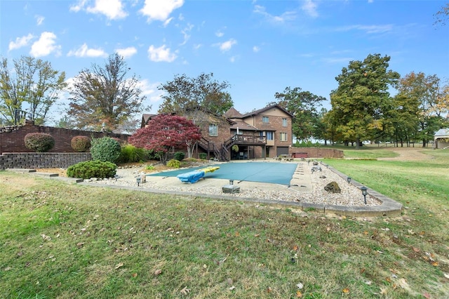 view of pool featuring a deck and a lawn