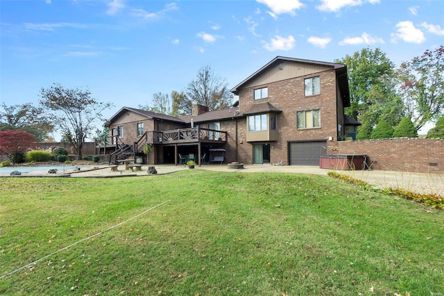 back of property with stairway, brick siding, a garage, a wooden deck, and driveway