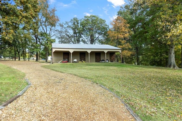 view of front of house with an outbuilding, a pole building, a front yard, and driveway