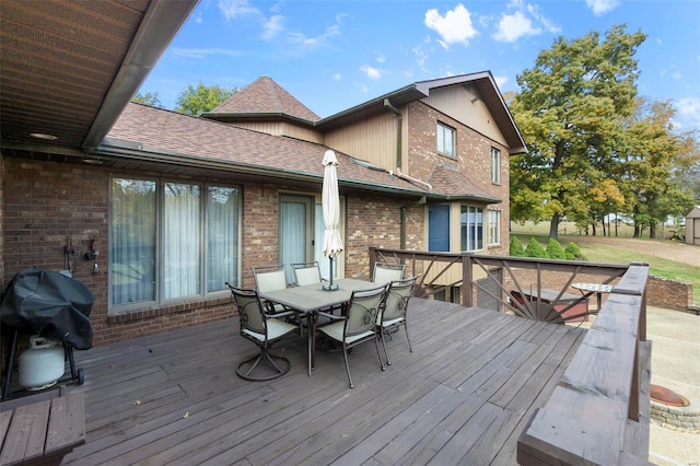 deck featuring outdoor dining space and a grill