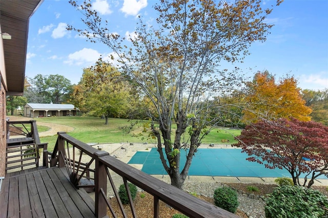 deck featuring a covered pool and a lawn