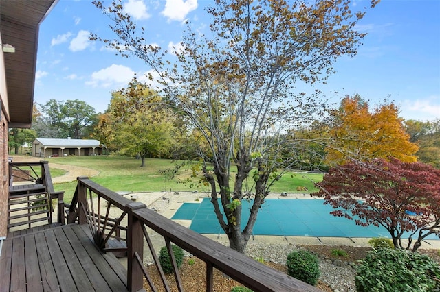 wooden terrace with a lawn and a covered pool