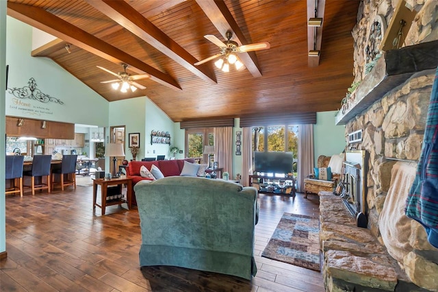 living room with a stone fireplace, beam ceiling, wooden ceiling, ceiling fan, and dark hardwood / wood-style flooring