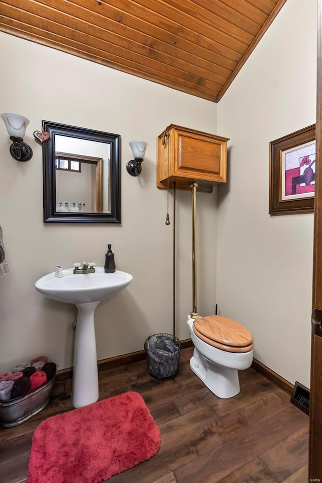 half bathroom featuring wooden ceiling, toilet, vaulted ceiling, baseboards, and wood finished floors