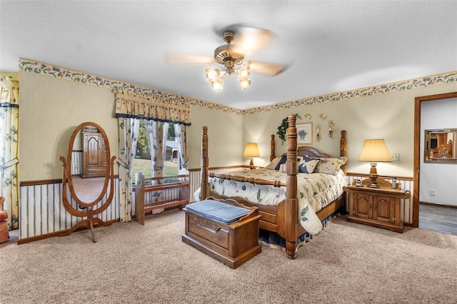 carpeted bedroom featuring ceiling fan and a textured ceiling