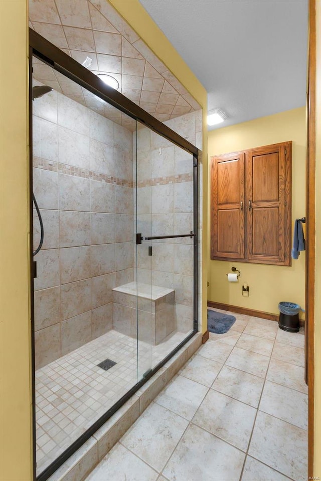 bathroom with a shower with shower door and tile patterned flooring