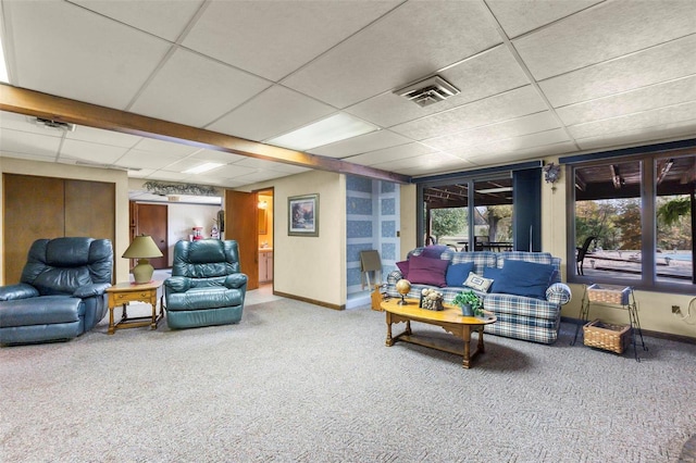 living area with baseboards, visible vents, carpet flooring, and a drop ceiling