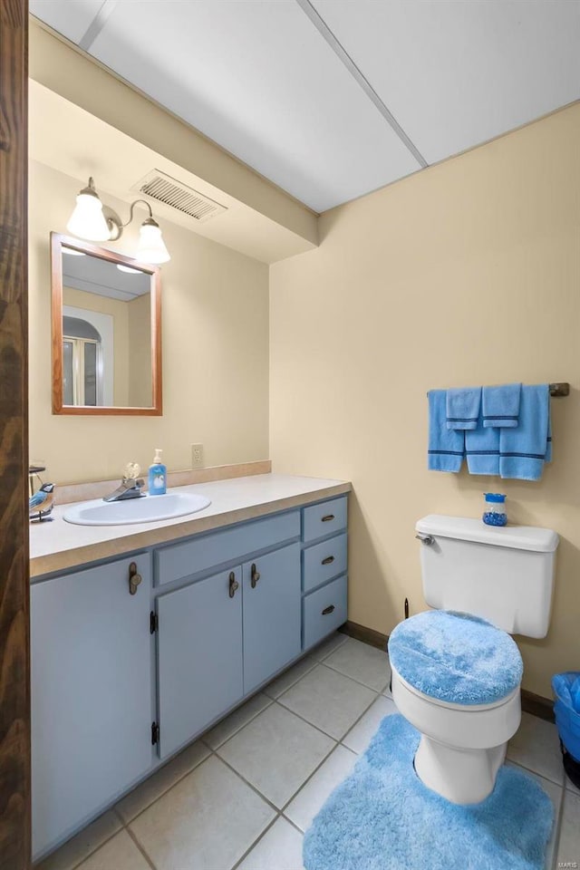 bathroom with visible vents, baseboards, toilet, tile patterned floors, and vanity
