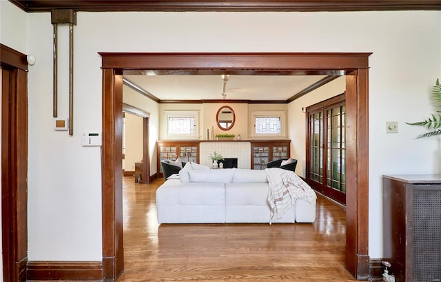 living room with crown molding, hardwood / wood-style flooring, and a tile fireplace