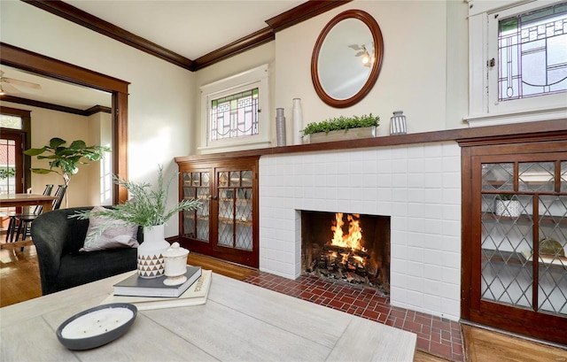 living room featuring crown molding, plenty of natural light, dark hardwood / wood-style floors, and a tile fireplace