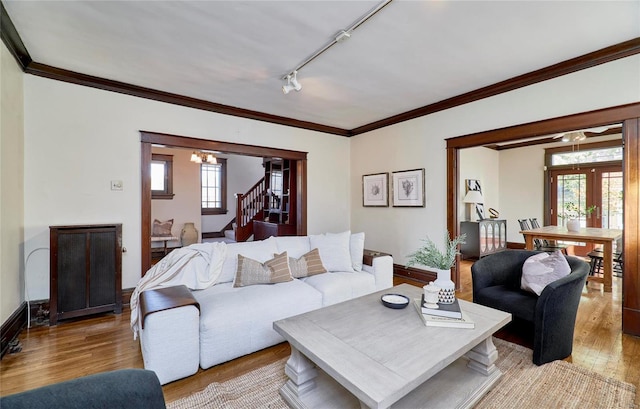 living room with french doors, ornamental molding, track lighting, and light wood-type flooring