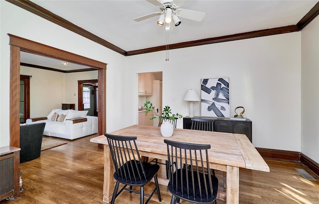 dining space featuring ceiling fan, crown molding, and dark hardwood / wood-style flooring