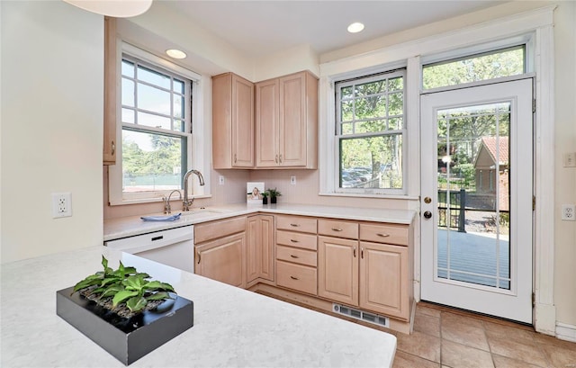 kitchen featuring light brown cabinets, dishwasher, tasteful backsplash, and sink