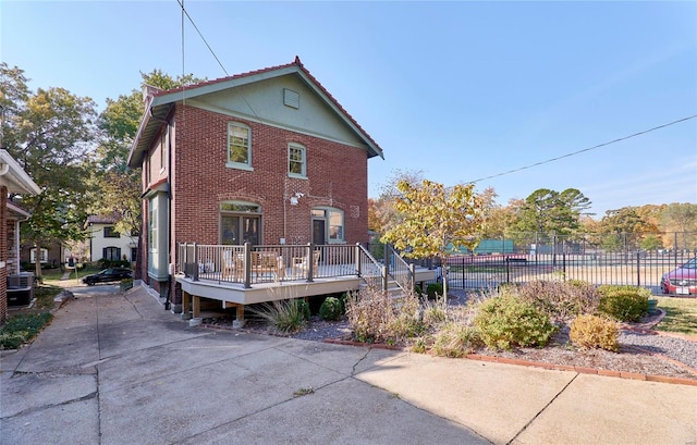 rear view of house with a wooden deck and cooling unit