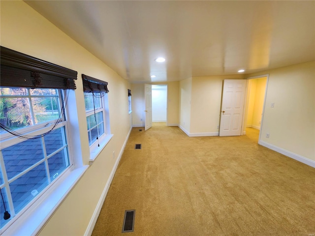 spare room featuring light colored carpet