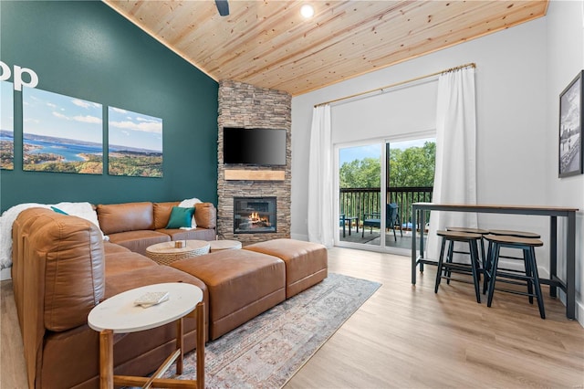 living room with light hardwood / wood-style floors, lofted ceiling, a fireplace, and wood ceiling