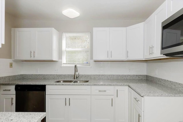 kitchen featuring stainless steel appliances, sink, white cabinets, light stone counters, and tasteful backsplash