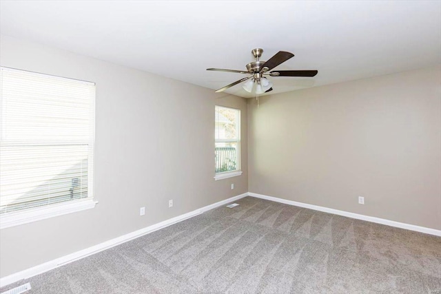 carpeted spare room featuring ceiling fan